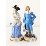 A pair of continental porcelain figure ornaments of a gentleman and lady both dressed in blue,