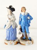 A pair of continental porcelain figure ornaments of a gentleman and lady both dressed in blue,
