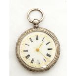 A silver fob watch with white face, Roman numerals, gold decoration,