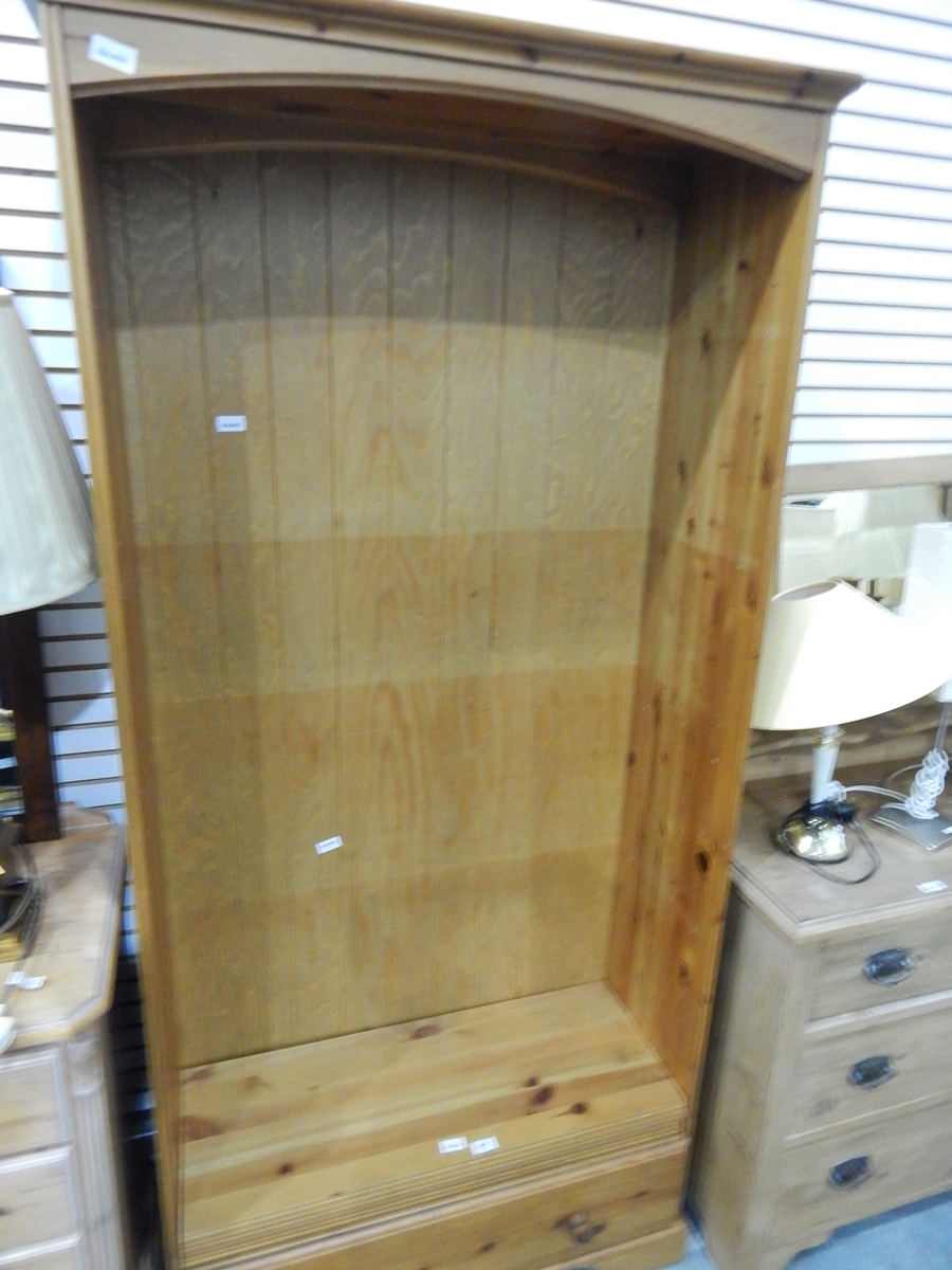 A modern pine bookcase with fitted drawer to base,