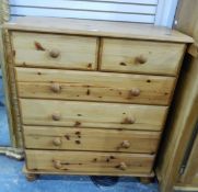 A pine chest of two short and four long drawers, each with wood knob handles and on turned feet,
