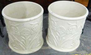 A pair of modern moulded cylindrical patio planters with applied floral and foliate decoration in