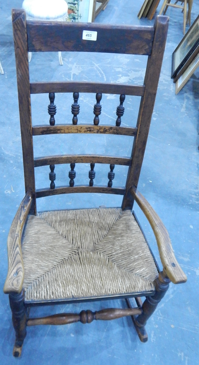 A 19th century rush seated oak and elm rocking chair with turned spindle galleries