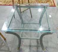 An oval metal framed glass topped two-tier lamp table