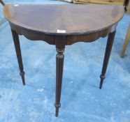 A reproduction mahogany cross-banded demi-lune hall table on three reeded tapering supports