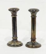 A pair of silver plated candlesticks of plain cylindrical form