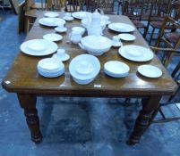 A late Victorian wind-out extending oak dining table on stout turned supports, brass castors,