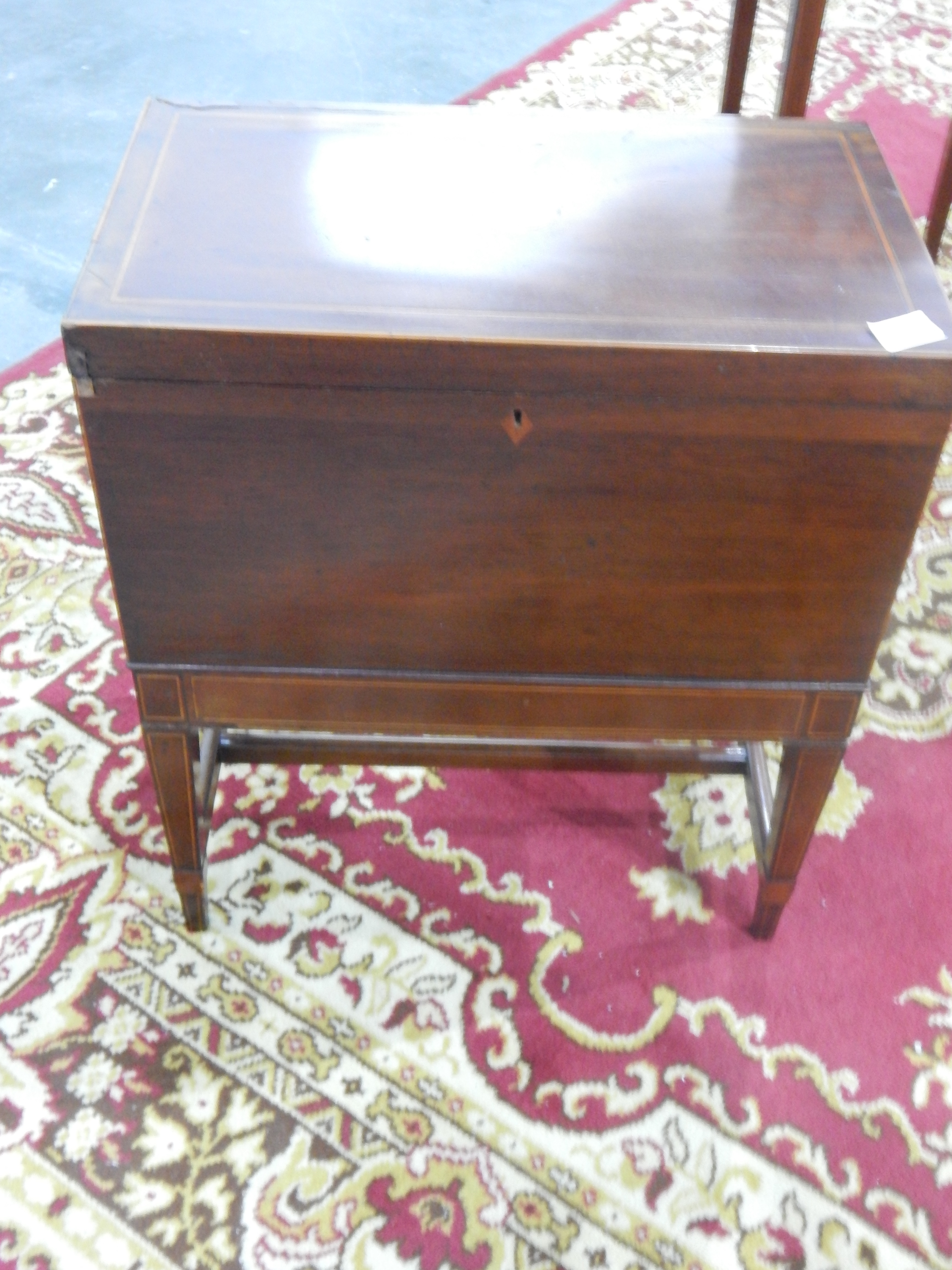 An Edwardian inlaid mahogany workbox on tapering square legs,
