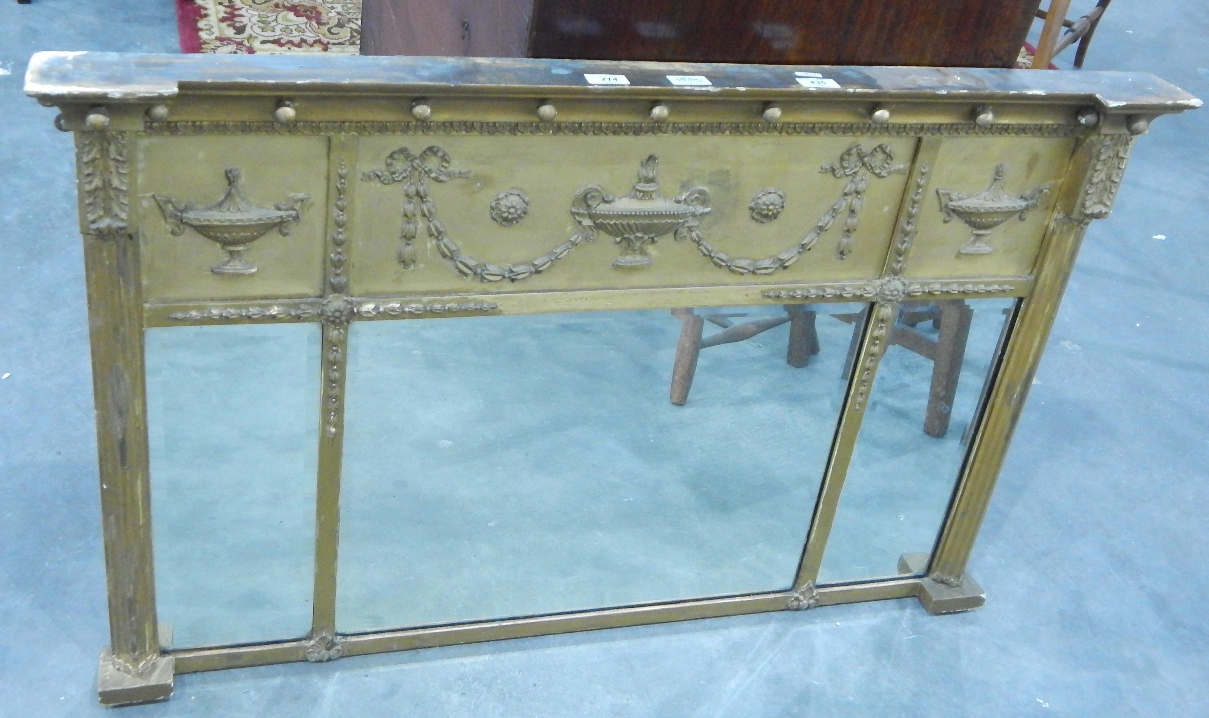 A rectangular gilt Regency style mirror with urn and swag decoration, with "Jones & Higgins,