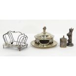 A silver plated mascot in the form of a begging dog, a canister with repousse decoration,