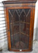 A mahogany hanging corner cupboard having dentil cornice over a astragal bi-glazed door,