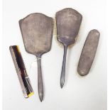 A silver backed dressing table set comprising two brushes, a hand mirror and a comb,