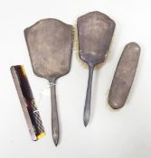 A silver backed dressing table set comprising two brushes, a hand mirror and a comb,