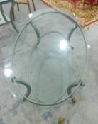 An oval metal framed glass topped two-tier conservatory table,