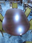 A reproduction mahogany extending dining table