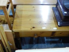 A pine side table fitted two frieze drawers and on turned supports,
