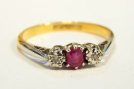 A three-stone diamond and ruby dress ring with 18ct gold shank