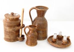 A group of French Caylus stoneware comprising a chamberstick, two jugs and a jar and cover,