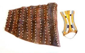 An African shell and beadwork skin apron type panel with metal charm adornments,