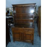 An early 20th century oak linenfold panel dresser by L Marcus Ltd, London,