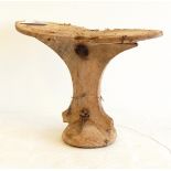 A collection of African tribal wooden headrests, some of pedestal form,