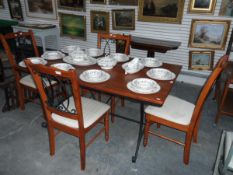 A modern teak finish dining table with metal under-frame and a set of four dining chairs