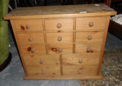 A pine chest of 13 short drawers together with a cast iron fireback depicting a flower with