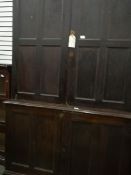 A stained pine linen press with two doors above, cupboard below,