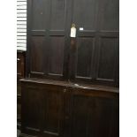 A stained pine linen press with two doors above, cupboard below,