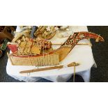 A painted wooden model boat with woven papyrus sails,