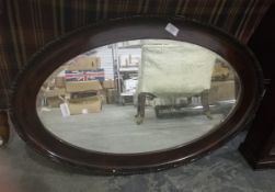 An oval mirror in mahogany frame,