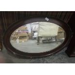 An oval mirror in mahogany frame,