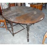 An antique oval oak fall-flap gateleg table on turned supports