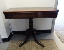 A Victorian mahogany fold-over card table on bulbous turned columns, cabriole legs with paw castors,