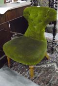 A green dressing chair with hour-glass shaped back,