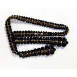 A French jet and gilt metal crossover necklace with faceted beads