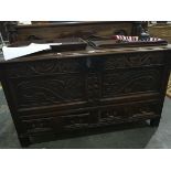 An 18th century oak mule chest with floral carved decoration and carved dragons, drawers to base,