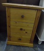 A modern pine side cabinet with three short drawers, on block plinth,
