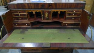 An early 19th century cross banded and inlaid mahogany straight front secretaire with fitted
