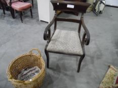 An early 19th century mahogany carvers dining chair with reeded scroll arms and sabre legs and a