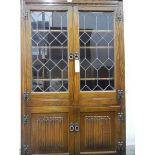 A reproduction glass fronted display cabinet with four shelves and cupboard, linenfold decoration,