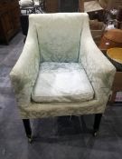 A small open armchair with green and white patterned covering,