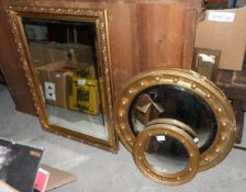 A gilt circular porthole shaped mirror and two others