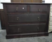 A stained wood chest of two short and two long graduated drawers, teardrop handles, on plinth base,