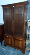 A mahogany glass fronted bookcase with three shelves and cupboard below, on shaped bracket feet,