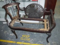 An Edwardian mahogany settee, the show frame with central pierced and carved oval scroll arms,