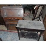 Oak stained table and an oak bureau with carved decoration and brass hinges