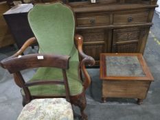 A mahogany carved open armchair with green fabric, the arms decorated with feathers and eagle heads,