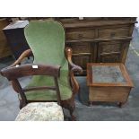 A mahogany carved open armchair with green fabric, the arms decorated with feathers and eagle heads,