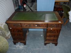 A reproduction mahogany kneehole desk with leather inset top and an arrangement of seven drawers,